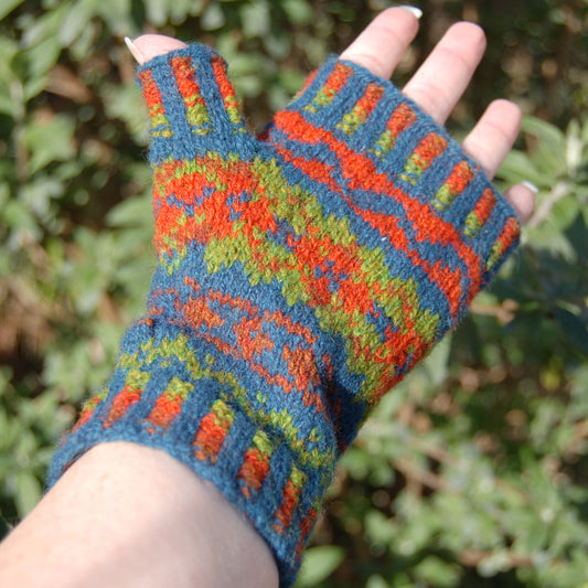 Colorful knitted fingerless gloves held against a natural background