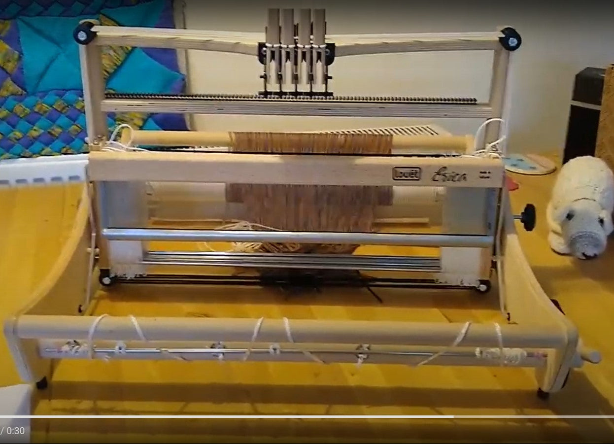 An Erica 4 shaft loom, 50cm wide, displayed on a table, showing the heddles and shafts